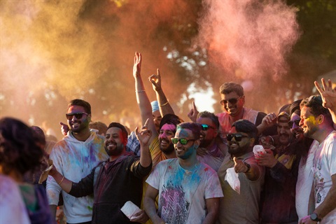 Image shows happy people gathering together with faces covered by colours