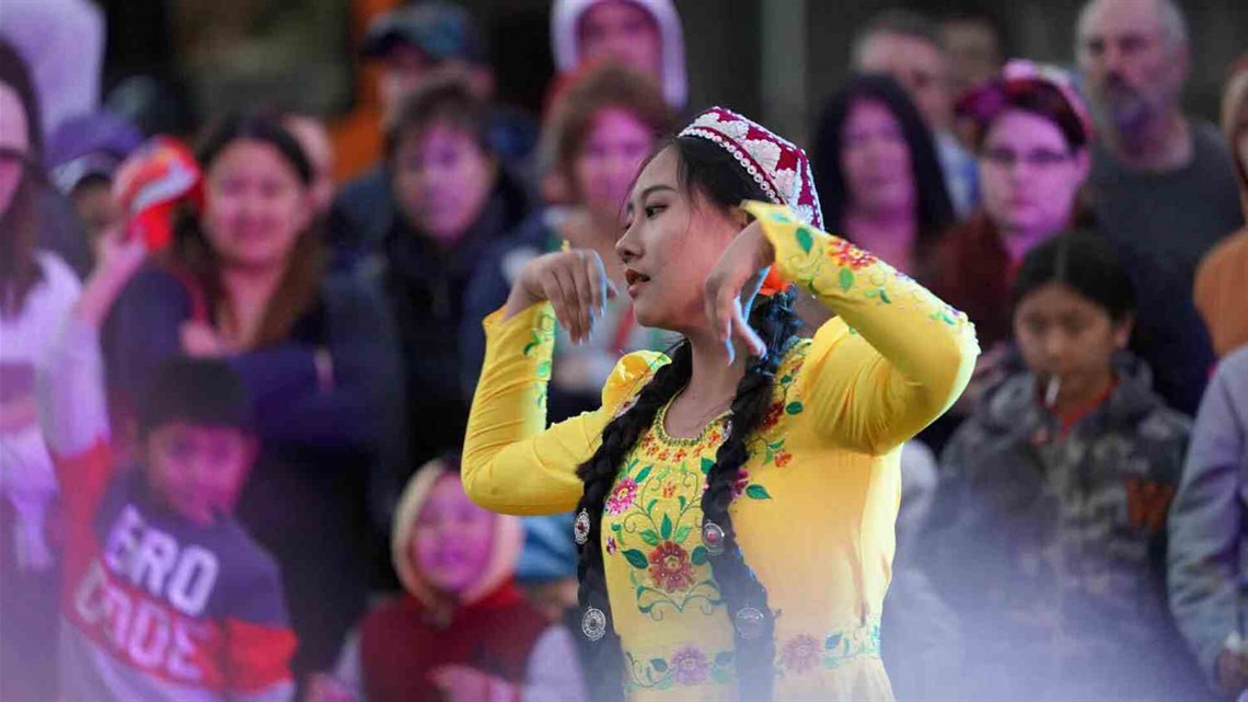 Woman in traditional dress dancing at the festival.