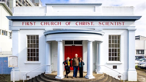 People stand on the steps outside the newly renovated neo-classical church.