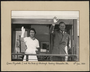 Queen Elizabeth II and Prince Philip, the Duke of Edinburgh stand at the back of a train, waving to the crowds, 8 January 1954.