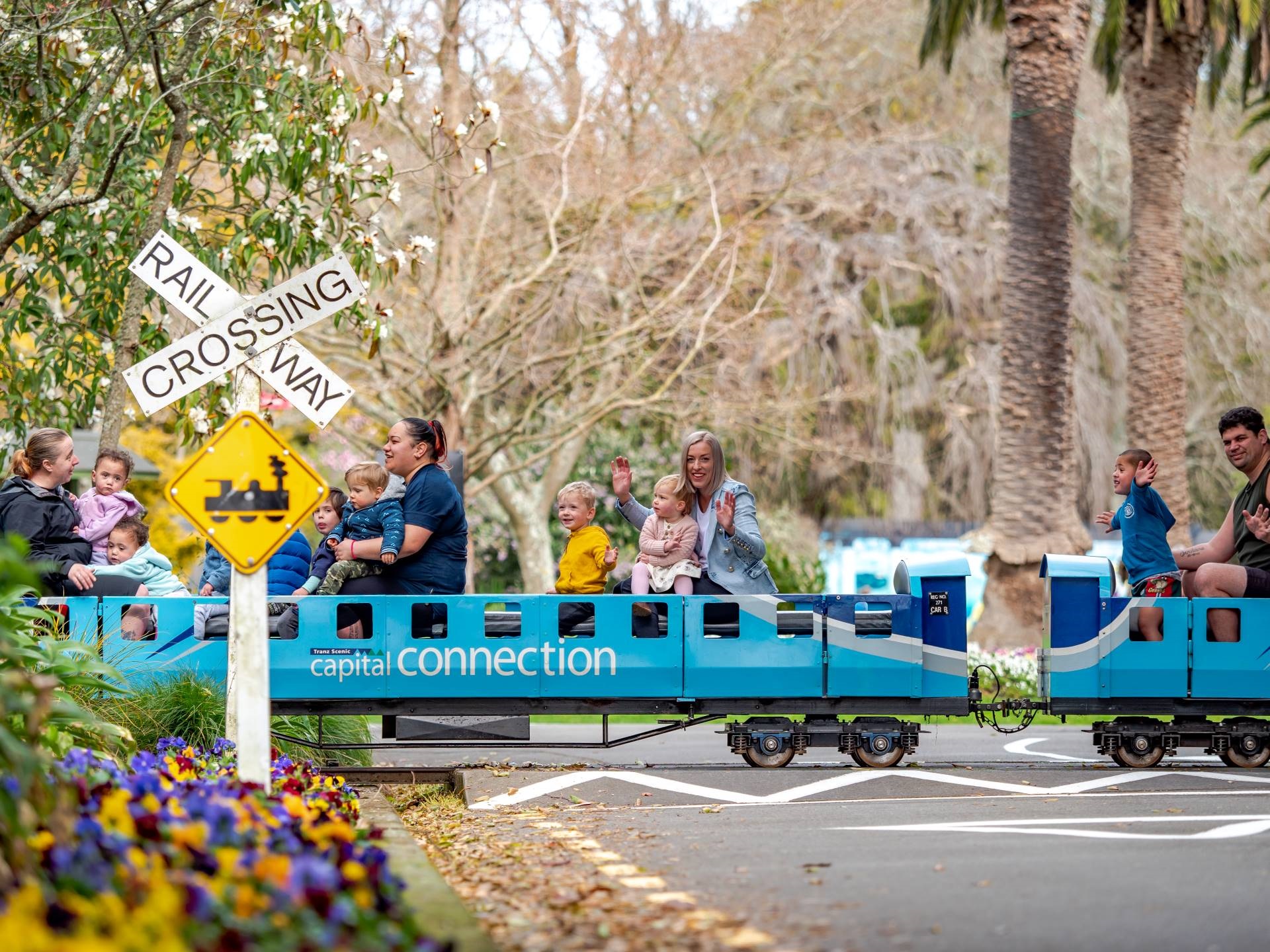 Photo shows families riding on miniature train at a railway crossing in the Esplanade.