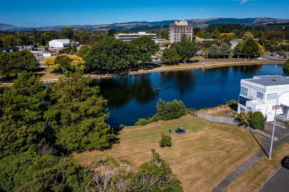 Image of ariel view of a picnic table and grass by the lagoon.