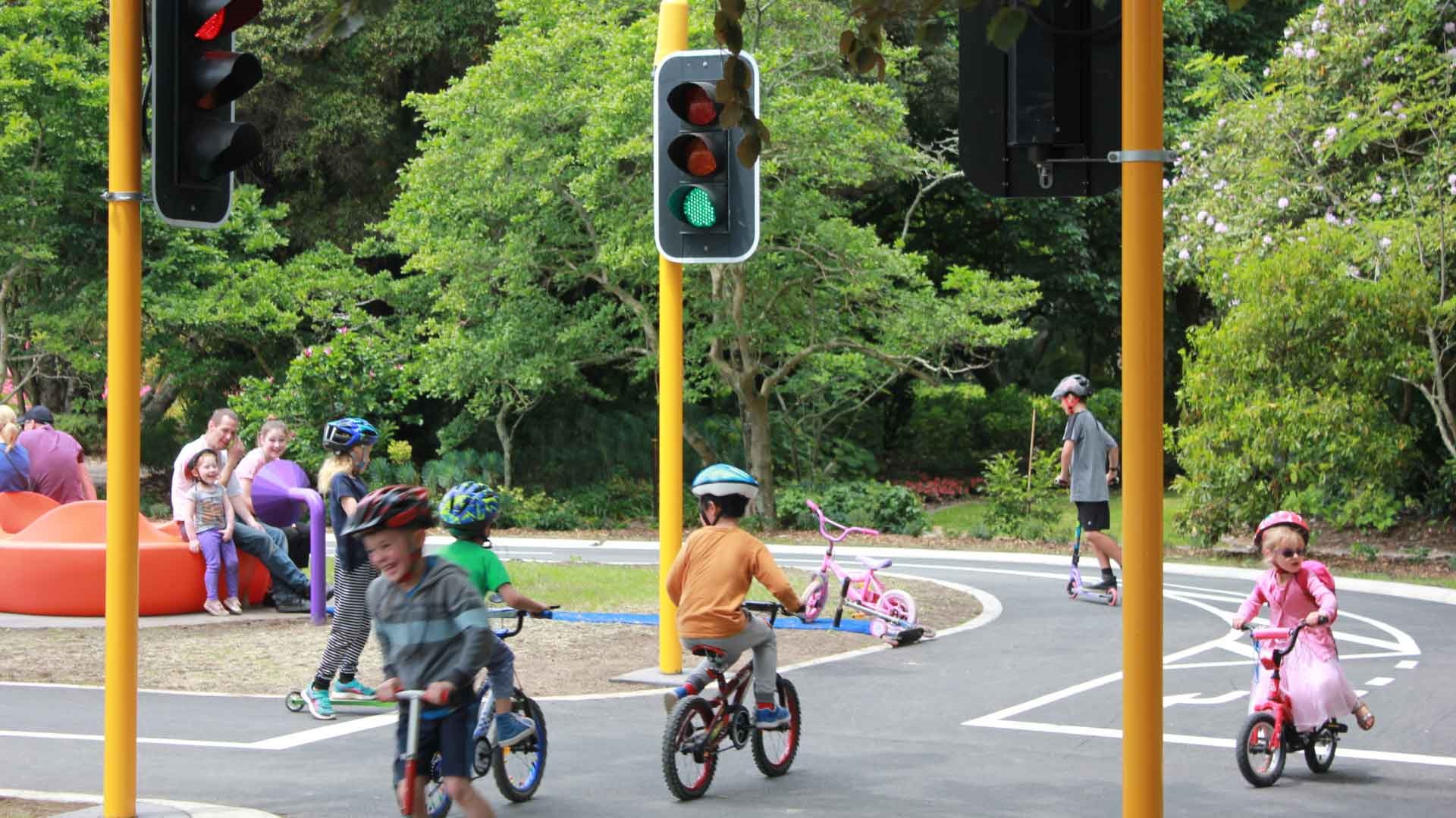 Photo shows gleeful kids on bikes in the road safety park.