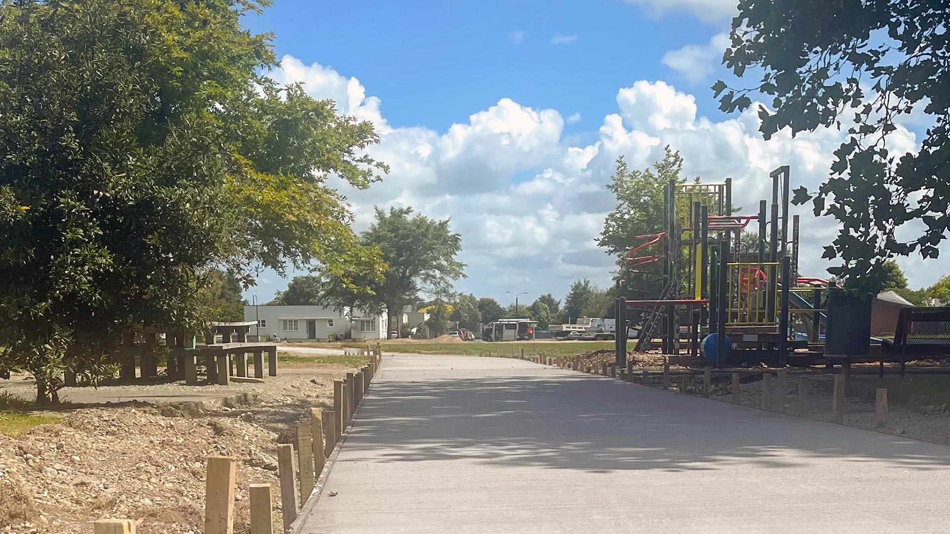 Photo shows a newly paved pathway in the Savage Reserve, with the playground on road sides.