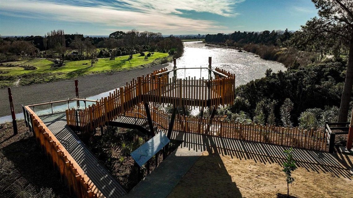 Picture shows a two-story lookout platform sitting next to the river and bush.