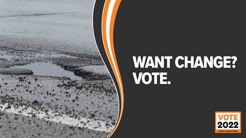 A pothole on road overlaid with text that reads: Want change? Vote.