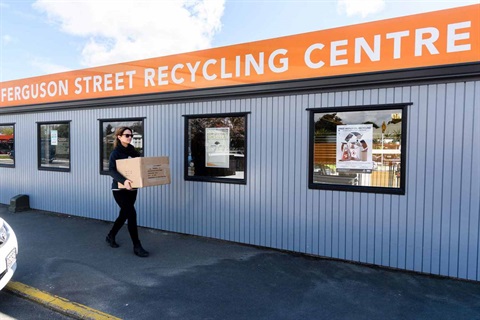 Photo shows woman with a box of recycling on the footpath outside the Ferguson St recycling centre.