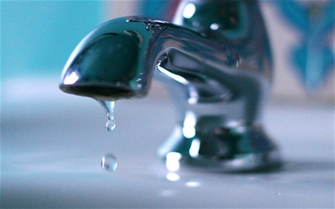 Photo shows a tap dripping water into a basin.