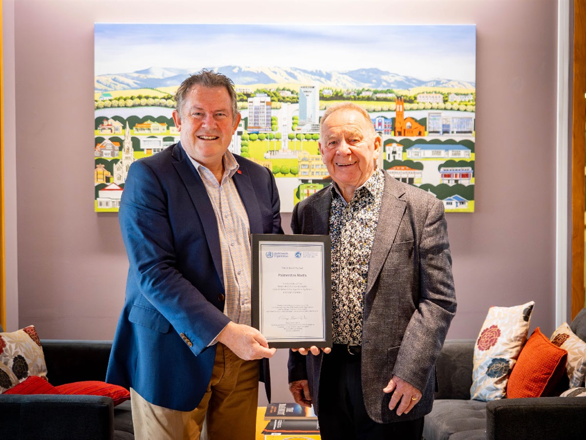 image shows mayor Grant Smith holding the age friendly certificate with another man