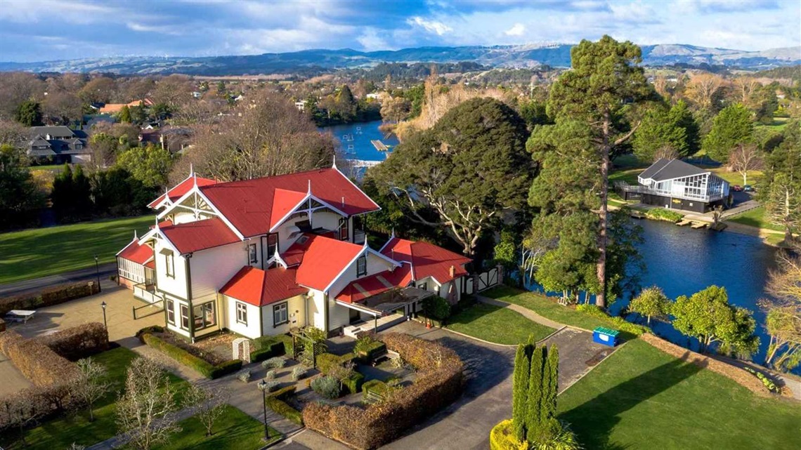 A beautiful historic homestead with manicured gardens set among trees near the lagoon.