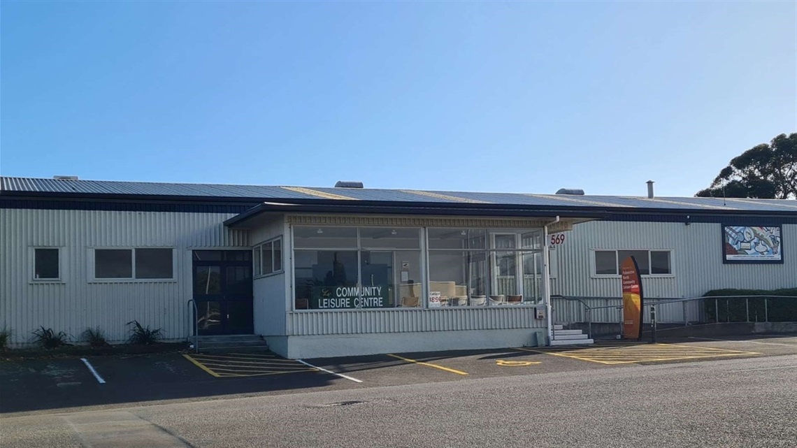 A long single-storey community centre with two doorways and a ramp from the carpark immediately outside.