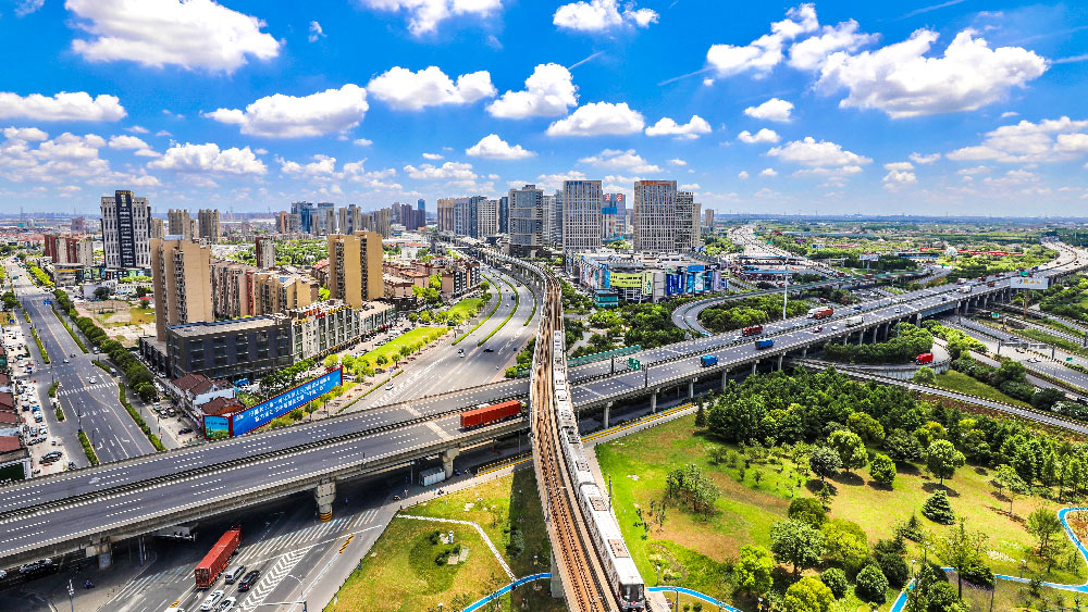 image shows aerial view of a city with multiple high-rise buildings and overhead bridges