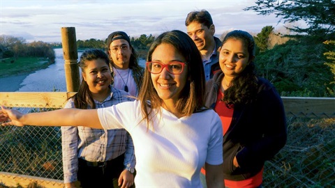 five students having a group photo by the river