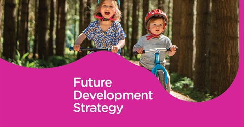 Image shows two kids riding balance bike through a bush, with text 'future development strategy'