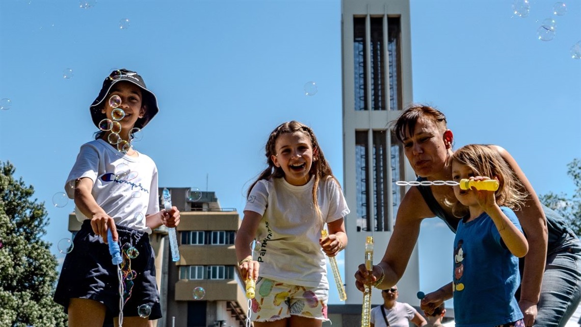 Laughing children playing with bubbles in Te Marae o Hine.