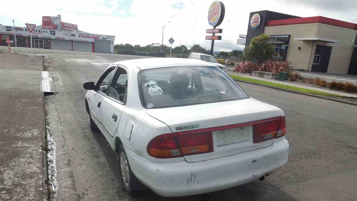 A car with no number plates dumped on roadside.