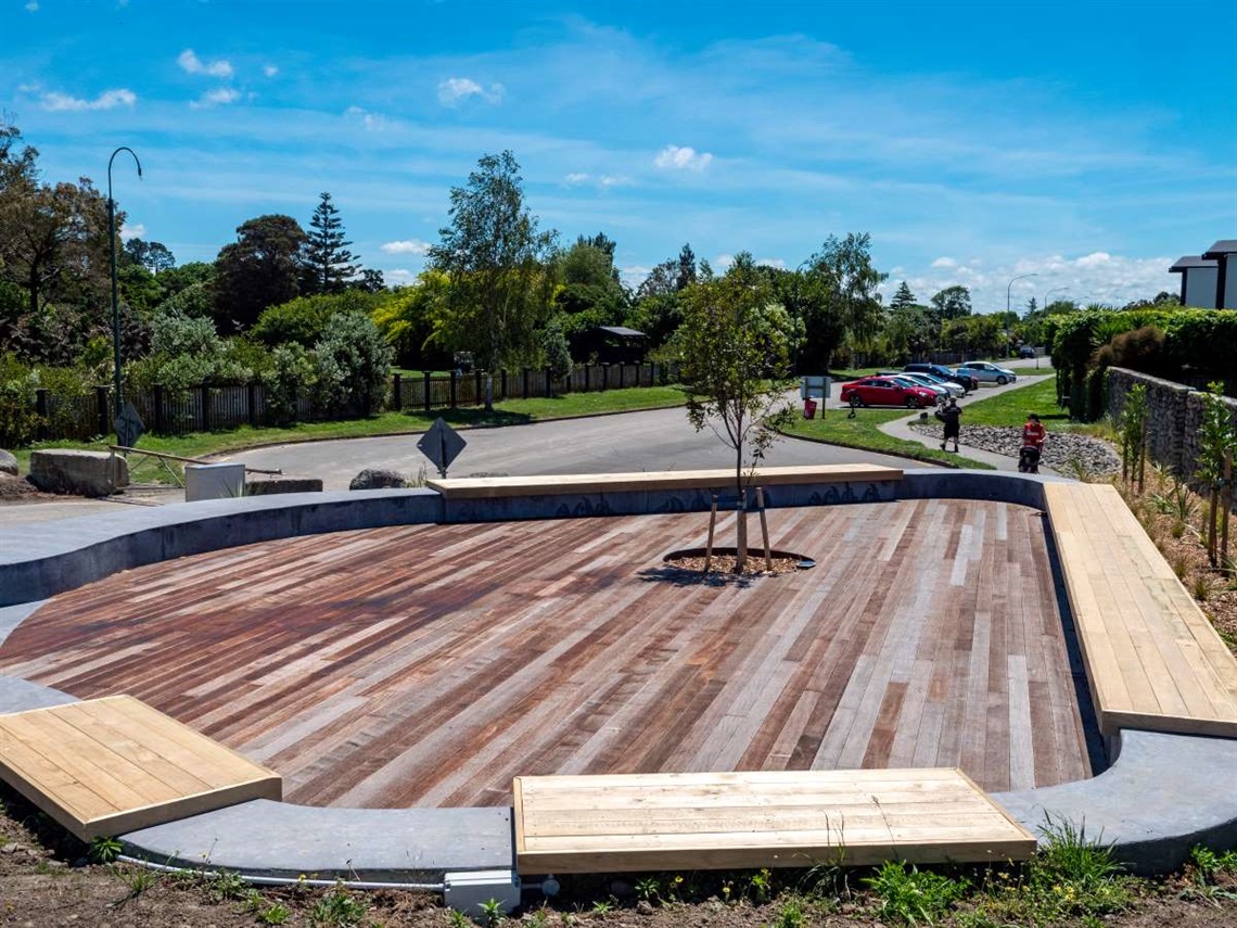 A circular wooden deck surrounded by built-in seats at the new river entrance.