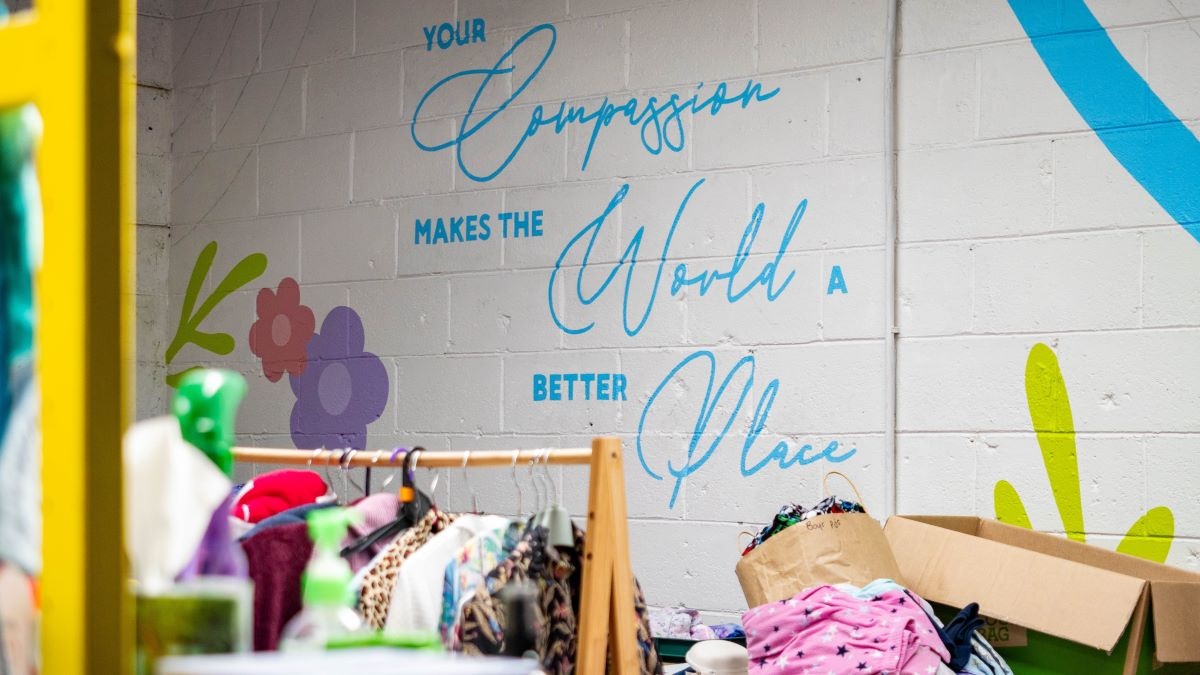 Donated clothes in the workshop, where the wall bears the legend: Your compassion makes the world a better place.