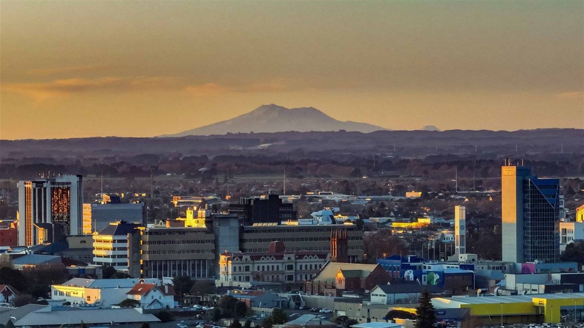 Aerial view of Palmy with the council building looming in the foreground and Mount Ruapehu on the horizon.