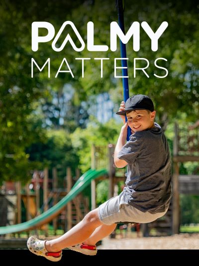 Joyous child on a rope swing in a Palmy park.