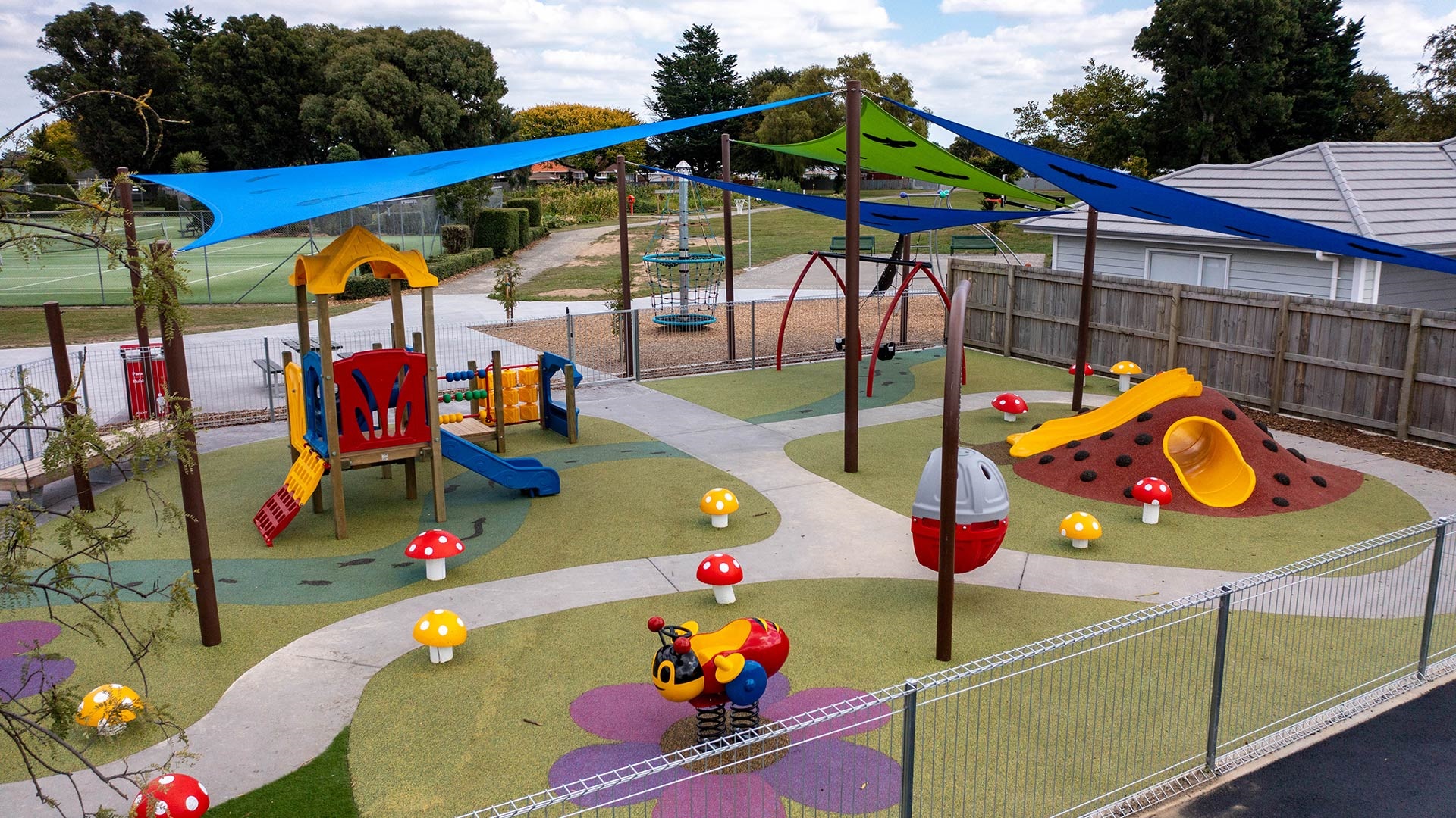 Image shows a playground with metal fence.