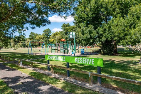 Image shows a playground surrounded by trees.