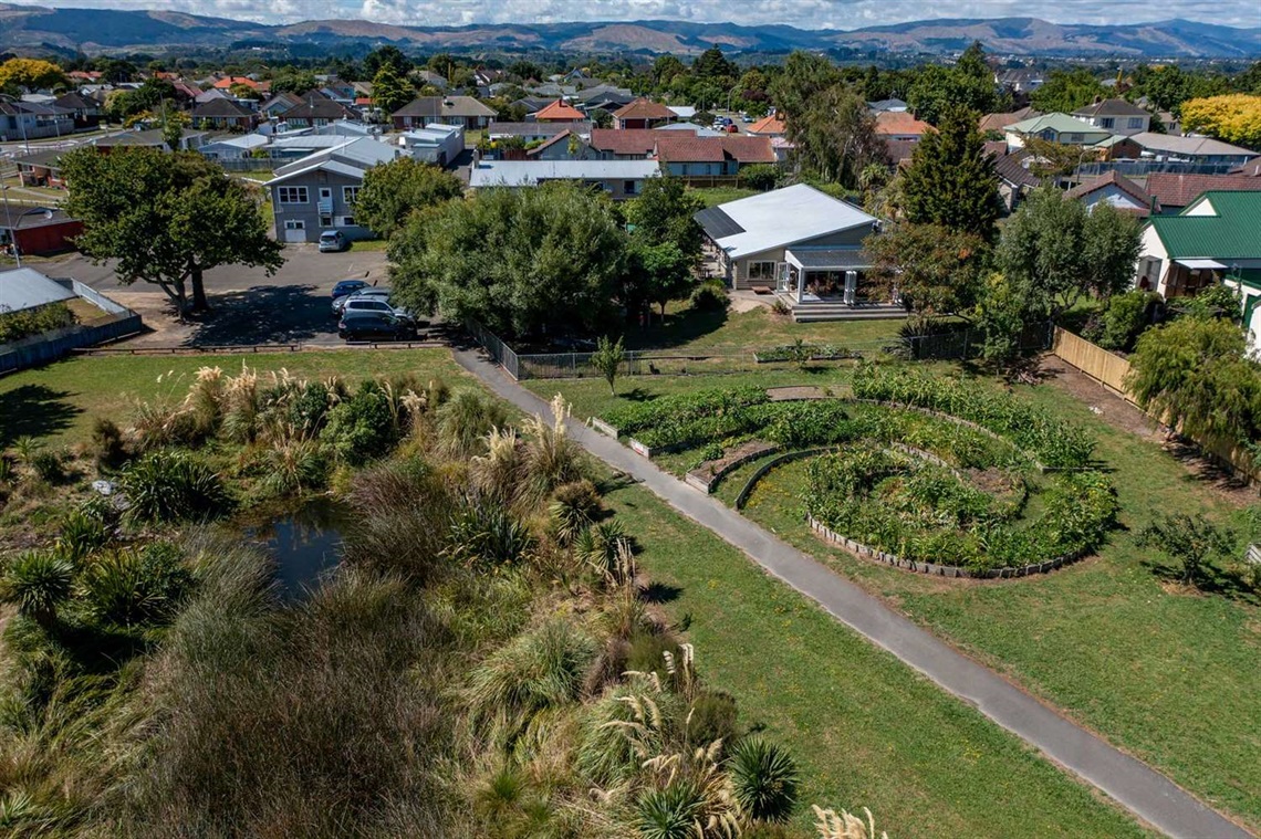 Image shows aerial view of a garden next to a stream