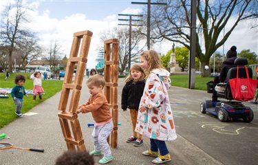 Littles playing Jenga at a pop-up in Te Marae o Hine.