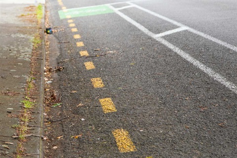 Image shows broken yellow lines on street