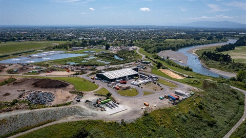 Image shows aerial view of a rubbish recycling centre and a water treatment plant next to a river
