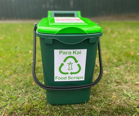 Image shows a food scraps bin on the grass
