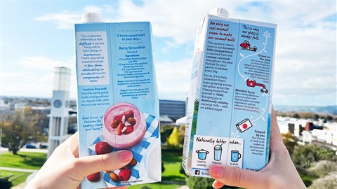 Two liquid paperboard packages under the sun with a clock tower at the background.