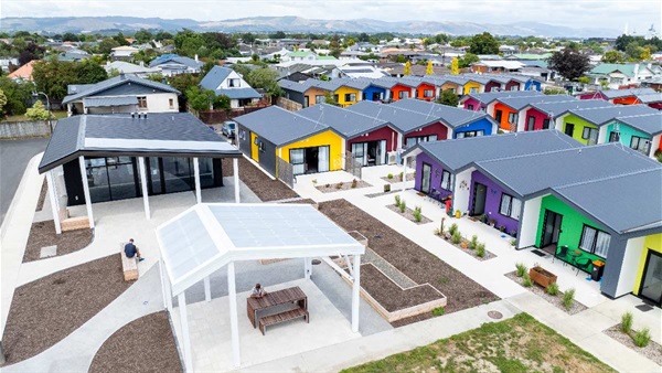 Image shows aerial view of newly built social housing units with colourful roof