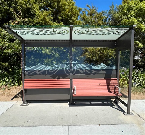 photo shows a bus shelter with glass cover