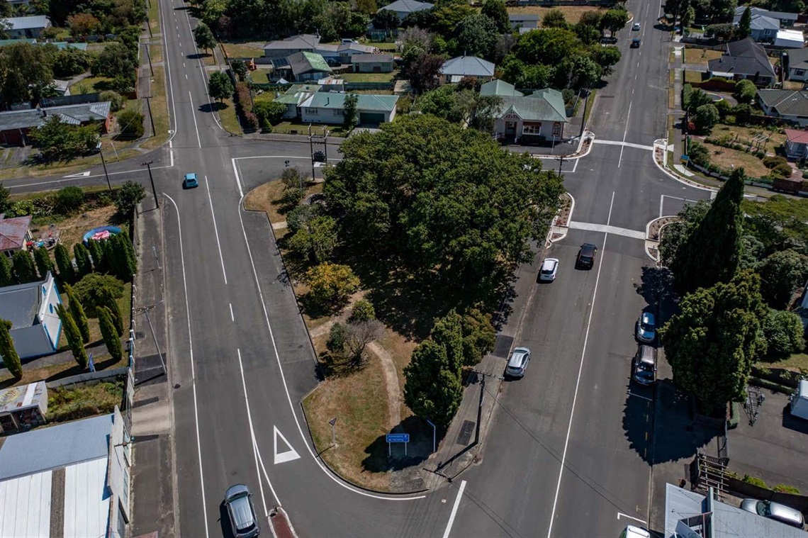 Image shows ariel view of grass and bush among roads.