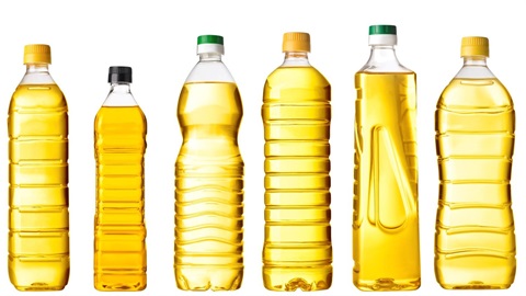 Photo shows six plastic bottles of cooking oil lined up in a row.
