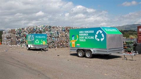 Photo shows council-branded event recycling trailers at Awapuni next to bales of compacted plastic.