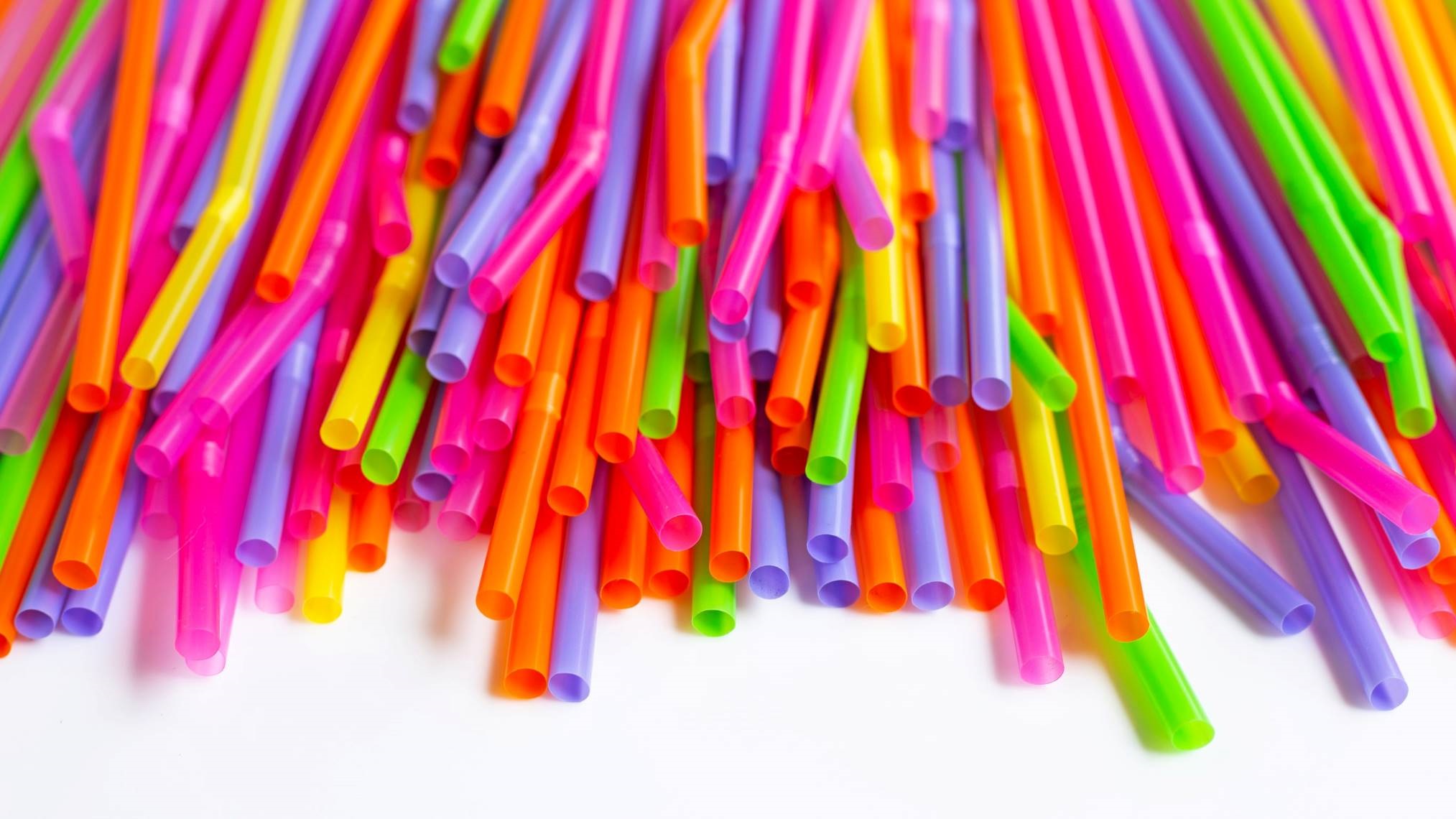 Shows brightly coloured, single-use plastic straws.