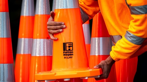 Extreme closeup of orange road cones with reflective strips and emblazoned with the Fulton Hogan and Palmy logos.