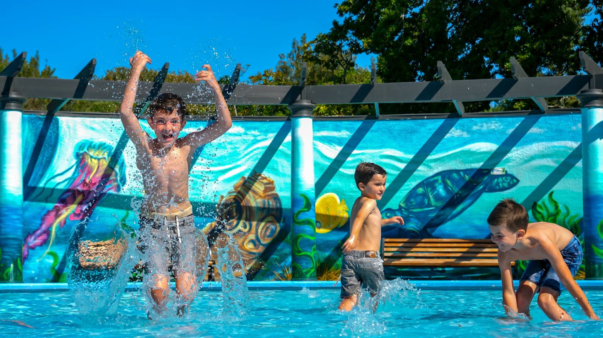 Photo shows children playing in the paddling pool.