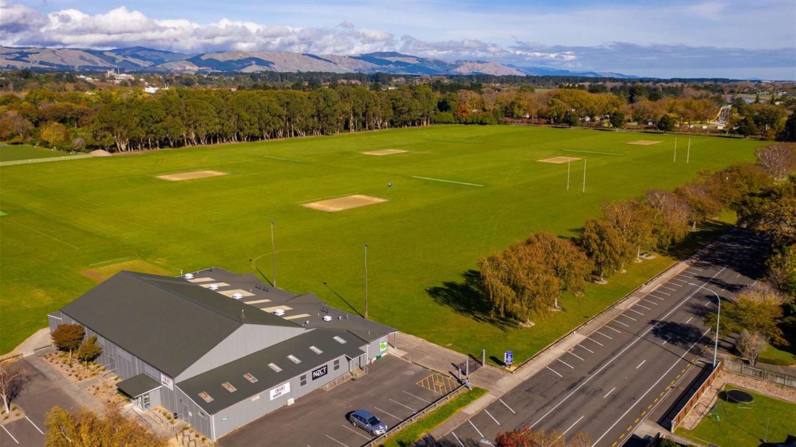 Photo shows aerial view of sportsgrounds with the Esplanade trees in the background.