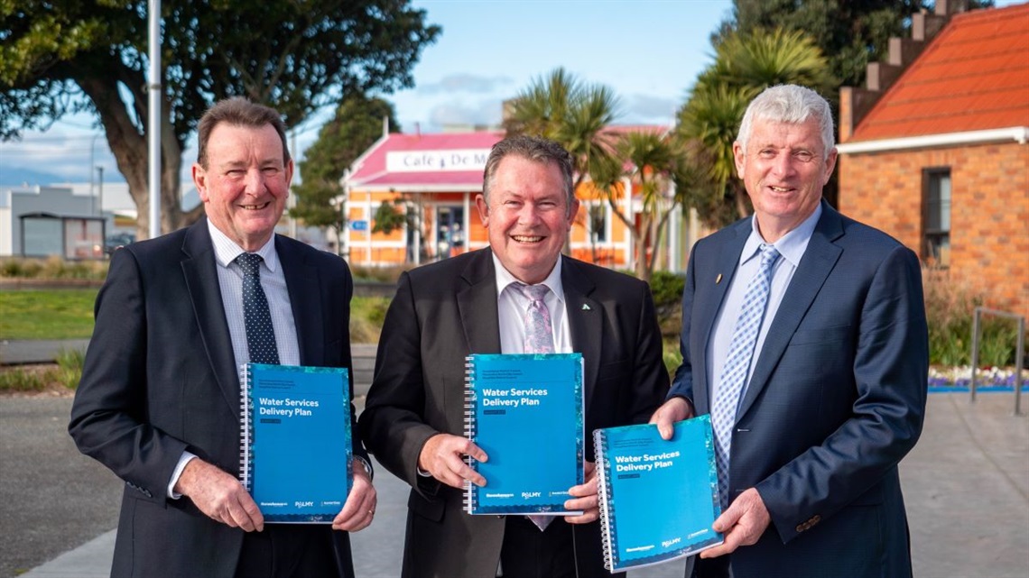 The mayors of Horowhenua, Palmerston North and Rangitīkei Councils holding the new joint water services plan being submitted to the government.